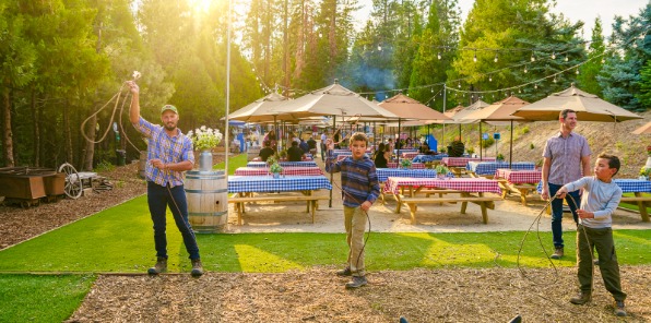 two adult men and two boys throw lassos at targets at the Gold Rush BBQ at Tenaya at Yosemite