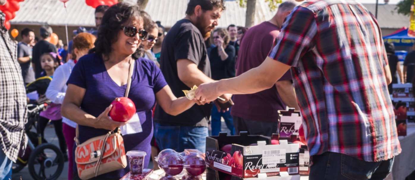Pomegranate, Fruit and Nut Festival Promotional photo, someone buying pomegranates