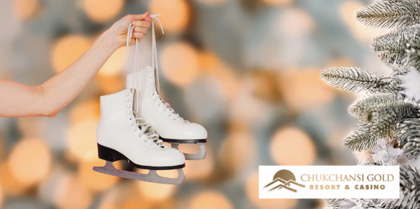 Woman holding up white ice skates next to a Christmas tree.