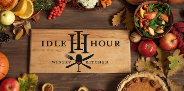 A table full of thanksgiving food sorounding a cutting board with the Idle Hour Winery logo.