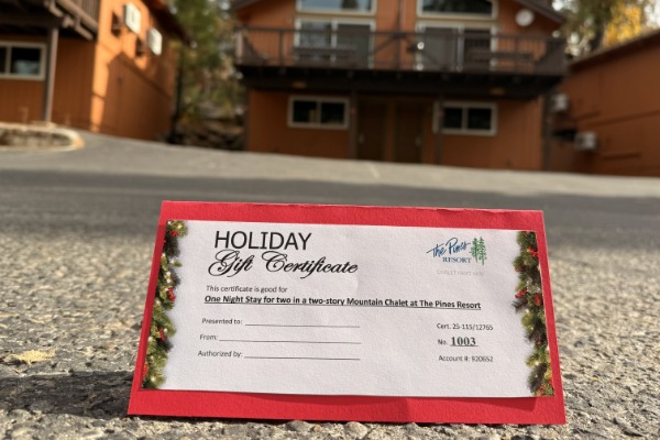 Image of a gift card in front of the pines chalet rooms.
