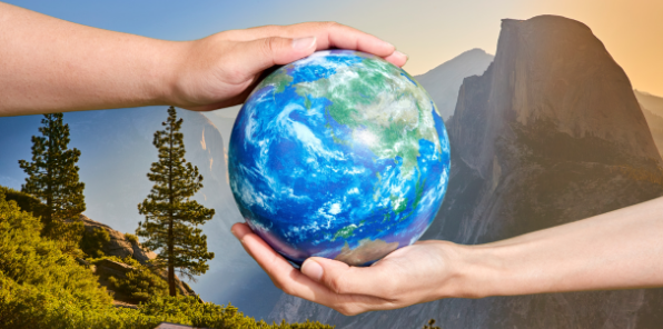 Two hands touching an earth globe with Yosmeite in the background.