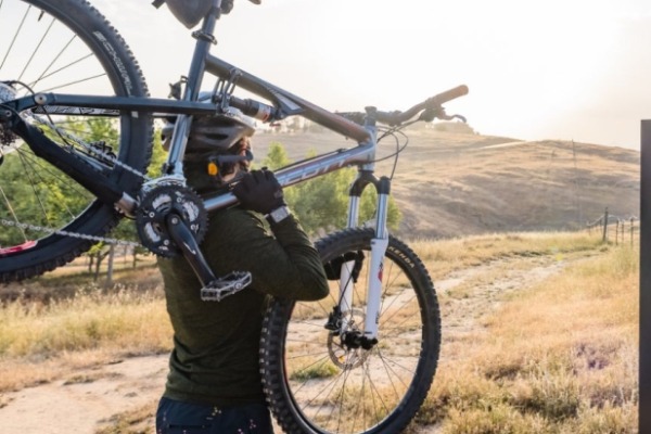Person with bike in from of trail sign.