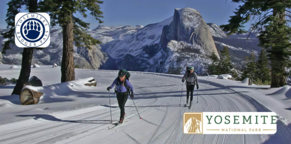 Two cross-country skiiers on Glacier Point road in the winter.