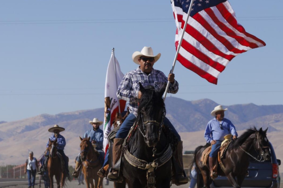 man on horse carrying an American flag
